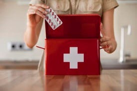 Lady putting medication into first aid kit