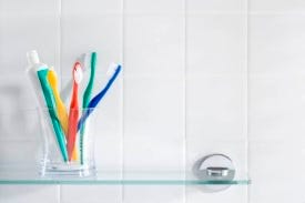 Toothbrushes in a glass in the shower