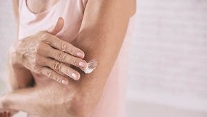 Lady applying moisturiser to her arm